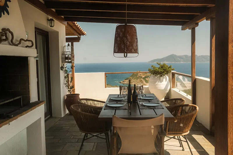 The barbecue and dining area on the covered terrace, facing the sea