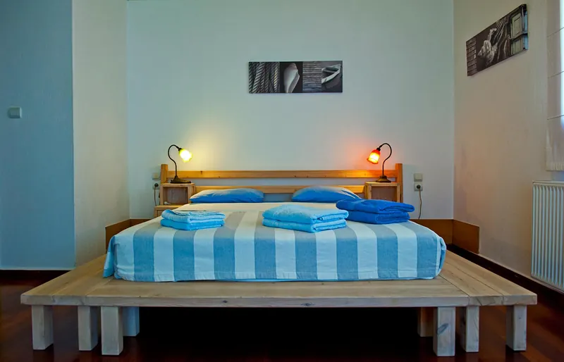 A bedroom with a blue-striped bed