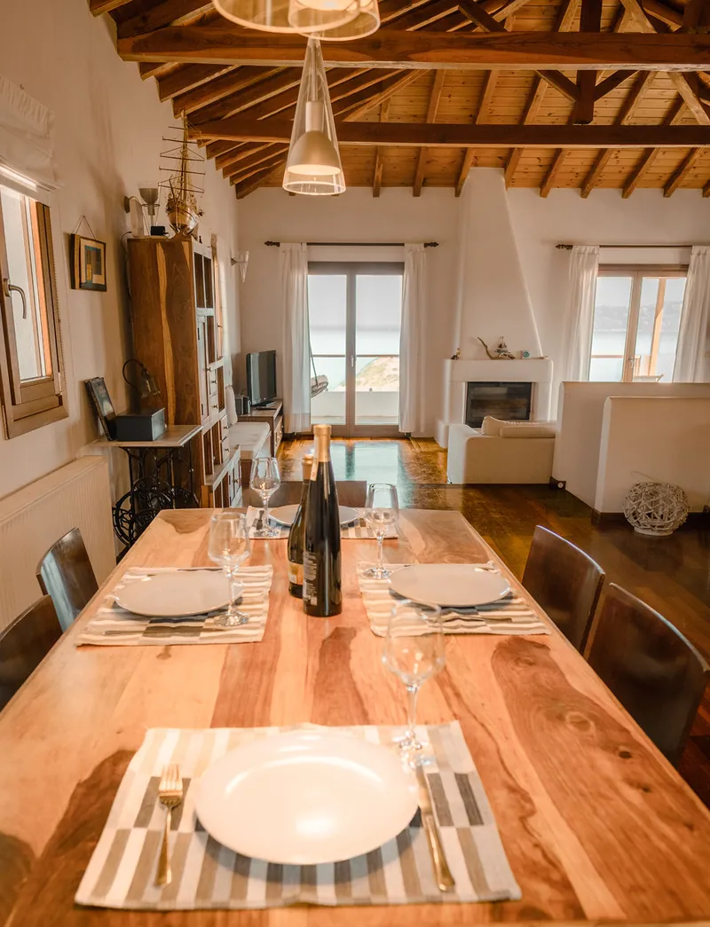 The dining table set for a meal under the timber roof