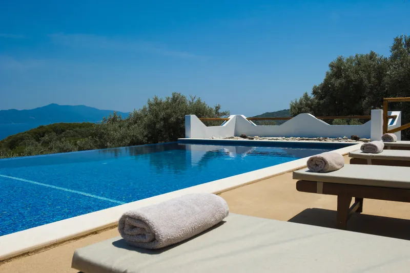 Loungers with rolled towels at the pool’s edge