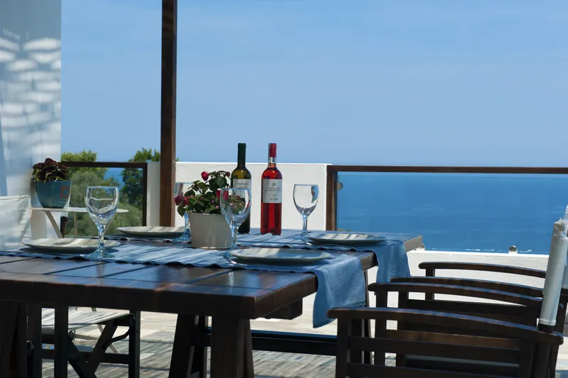 A table set for dinner on the terrace, overlooking the sea