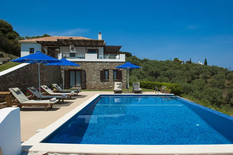 The villa, the pool and blue umbrellas