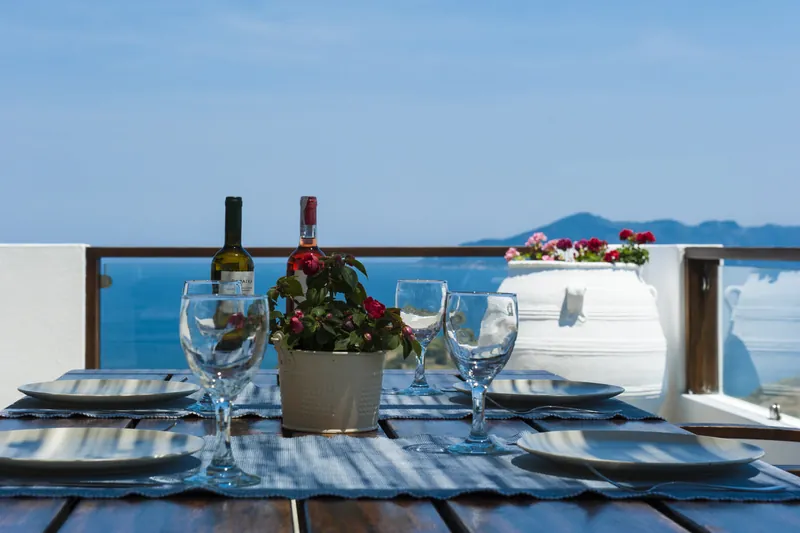 Wine and glasses on the terrace table above the sea